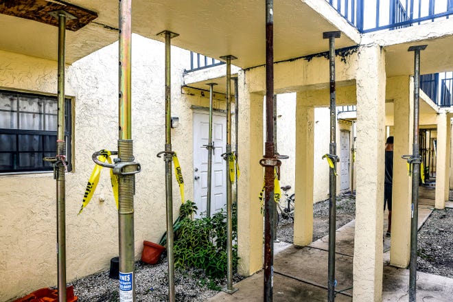 Poles holding up a foundation on a condo walkway 